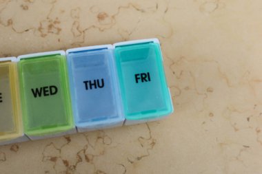 Gökkuşağı renkli ilaç kutusunu her gün işaretli olarak haftada üç gün için kapat (Çarşamba, Perşembe ve Cuma))