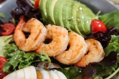 Avokado, karides, karides, haşlanmış yumurta, vişneli domates ve sebzeli sağlıklı salata.