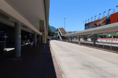 Batı Liman Tüneli, Kowloon, Hong Kong - 4 Ağustos 2024: reklam panoları, otobüs limanı ve otobüs durağında bekleyen insanlar.