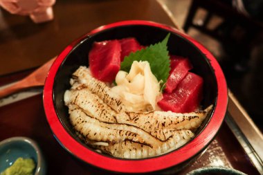Japon çiğ saşimi balığının kapağını kapat ton balığı düz balık pirinç donburi kırmızı ve siyah bir kase içinde.