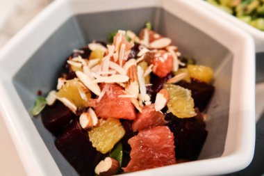 Soğuk salatayı pancar, fındık, greyfurt ve altıgen gri bir kasede yuzi ile kapat.