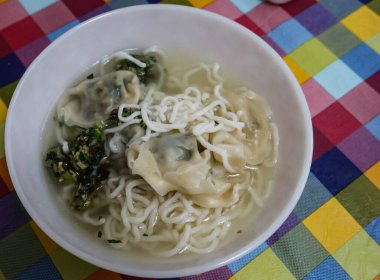Ev yapımı Çin usulü Hong Kong usulü haşlanmış beyaz şehriye, vejetaryen sebzeli hamur köftesi ve renkli masa örtüsü. Bir hamur tatlısı yayılarak parçalanmış.