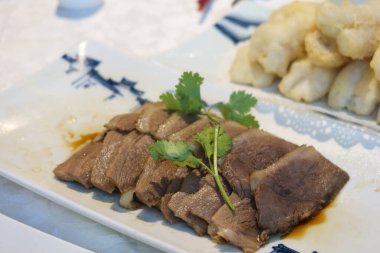 Çin usulü Chiu Chow ya da Chao Zhou usulü ince dilimlenmiş kaz filetosunu beyaz tabakta marine et.