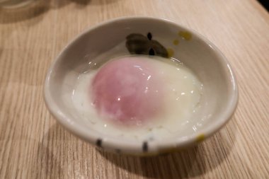 Japon haşlanmış onsen yumurtasını küçük bir tabakta yakın çekim yapın.