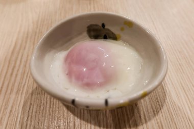 Japon haşlanmış onsen yumurtasını küçük bir tabakta yakın çekim yapın.