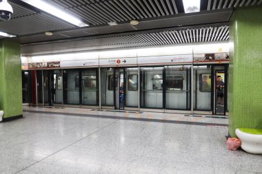 Ürdün, Hong Kong - 24 Ağustos 2024: MTR tren platformu ile Tsuen Wan Hattı 'na (Kırmızı Hat) yeşil sütunla gelen trenler