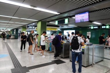 Ürdün, Hong Kong - 28 Ağustos 2024: MTR tren istasyonunun kapısından ayrılan yolcular