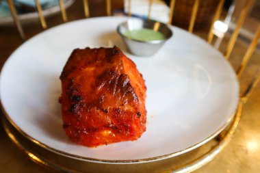 Hint tika somonuna yakın. Beyaz bir tabakta portakallı otlar.