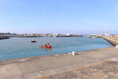 Howth, Dublin, Ireland- 6 Nisan 2016: Sahil kıyısı güzel bir mavi gökyüzü gününde kıyıda park etmiş bir sürü beyaz tekne.