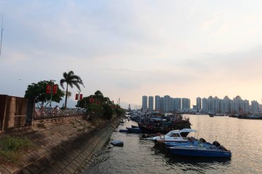 Castle Peak Bay, Sam Shing, Tuen Mun, Hong Kong - 15 Eylül 2024: Birçok balıkçı teknesi gün batımında Çinli turistlerle birlikte kıyıya yanaştı.