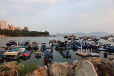 Castle Peak Bay, Sam Shing, Tuen Mun, Hong Kong - 15 Eylül 2024: Birçok balıkçı teknesi gün batımında Çinli turistlerle birlikte kıyıya yanaştı.