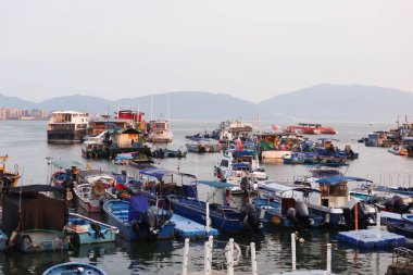 Castle Peak Bay, Sam Shing, Tuen Mun, Hong Kong - 15 Eylül 2024: Birçok balıkçı teknesi gün batımında Çinli turistlerle birlikte kıyıya yanaştı.