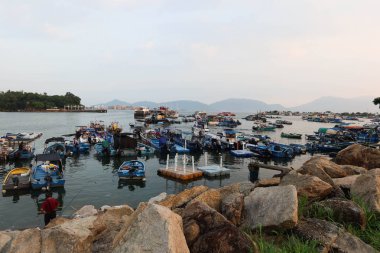 Castle Peak Bay, Sam Shing, Tuen Mun, Hong Kong - 15 Eylül 2024: Birçok balıkçı teknesi gün batımında Çinli turistlerle birlikte kıyıya yanaştı.