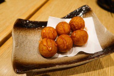 Altı parça kızarmış Japon peynirli patates topunu bir tabağa koy.