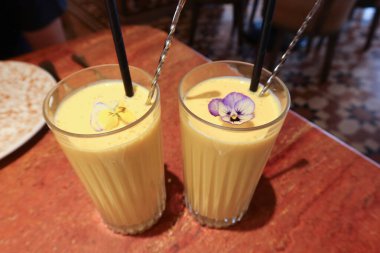 İki bardak Hint usulü soğuk mango Lassi içeceği.