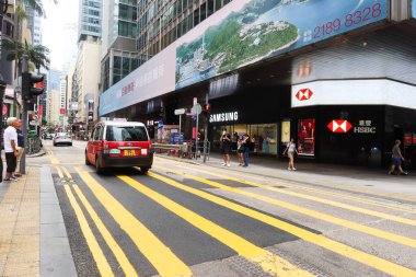 Central, Hong Kong- 18 Sep 2024: des voeux road traffic with cars, taxis and shops near by eg. HSBC bank or Breguet clipart