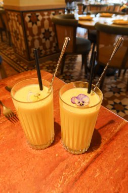 İki bardak Hint usulü soğuk mango Lassi içeceği.