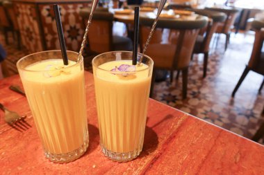 İki bardak Hint usulü soğuk mango Lassi içeceği.