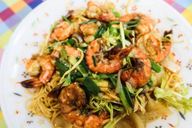 Hong Kong usulü Çin usulü ev yapımı karidesleri, beyaz tabakta yumurtalı erişteyle karıştırın.