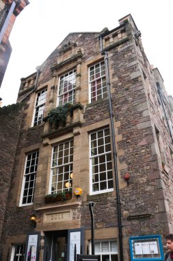 High Street, Old Town, Edinburgh, United Kingdom- 28 Ocak 2016: Yağmurlu bir günde binanın zemin katında dükkanları olan caddenin dışı