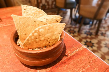 Kahverengi bir kaseye daldırmak için Hint çıtır Papadum bisküvileri.