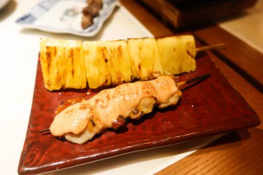 close up of Japanese skewer kushiyaki of pineapple and chicken pieces with pollock roe salad sauce clipart