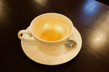 Sıcak yuzu reçelini beyaz çay fincanında limonata suyuna yakın tut.