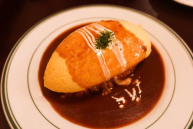 Japon yemeklerini yakın, yumurta omleti pilavı ve beyaz tabakta et sosu.