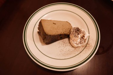 Earl Grey çay hojicha çayı aromalı kremalı ve çikolatalı peynirli kek ve yuvarlak tabakta.