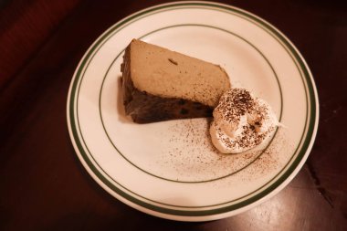 Earl Grey çay hojicha çayı aromalı kremalı ve çikolatalı peynirli kek ve yuvarlak tabakta.