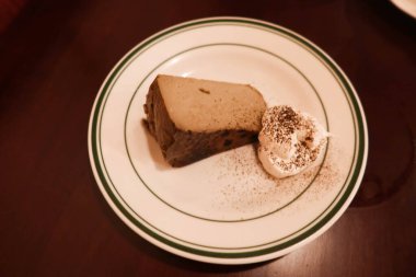 Earl Grey çay hojicha çayı aromalı kremalı ve çikolatalı peynirli kek ve yuvarlak tabakta.