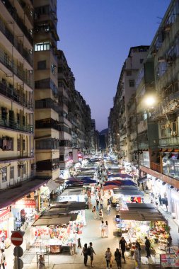 Hanımlar Pazarı, Mong Kok, Hong Kong - 12 Ekim 2024: her iki tarafında işportacı çadırı olan cadde indirimli giysi, yiyecek, bitki, meyve, gece vakti yürüyen birçok insanla birlikte hediyelik eşya satıyor.