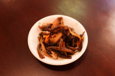 Japon aperatiflerini kapatın. Soğuk mantar, havuç ve dulavrat beyaz bir tabakta.