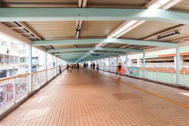 Mong Kok, Hong Kong - 24 Ekim 2024: Barınaklı yaya köprüsü üstgeçidi ve etrafta dolaşan insanlar