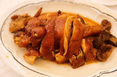 Beyaz tabakta soya soslu tütsülenmiş Çin tavuğunu yakın.