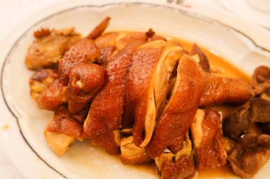 Beyaz tabakta soya soslu tütsülenmiş Çin tavuğunu yakın.