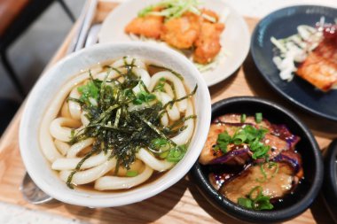 Çorbayı deniz yosunu, mantar aperatifi, ızgara somon balığı, patlıcan ve ahşap bir tepside küçük tabakta kızarmış tavuk ile kapat.