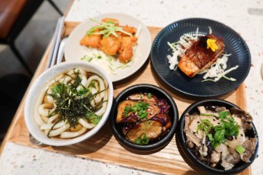 Çorbayı deniz yosunu, mantar aperatifi, ızgara somon balığı, patlıcan ve ahşap bir tepside küçük tabakta kızarmış tavuk ile kapat.