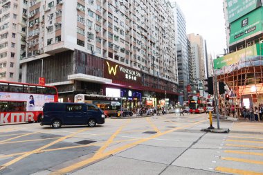 Yau Ma Tei, Kowloon, Hong Kong - 21 Ekim 2024: Gündüz vakti eski konut binaları, arabalar ve otobüslerle kalabalık sokak manzarası..