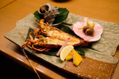 Japon ızgara büyük kral büyüklüğünde karideslerin yarısını limon dilimi ve kabuklu deniz ürünleri ile ikiye bölün.