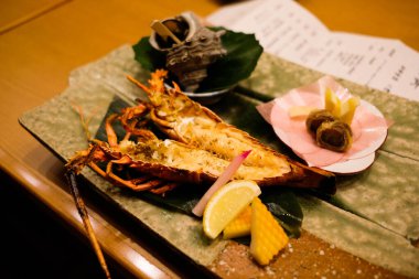 close up of Japanese grilled big king size prawns opened in two sides in half with lemon slice and shellfish at the back clipart