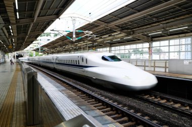Atami, Japonya- 30 Ekim 2024: JR (Japonya Demiryolu) Merkez N700 Shinkansen mermi treni gündüz vakti istasyona yüksek hızda giriş yapıyor.