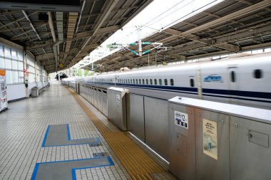 Atami, Japonya- 30 Ekim 2024: JR (Japonya Demiryolu) Merkez N700 Shinkansen mermi treni gündüz vakti istasyona yüksek hızda giriş yapıyor.