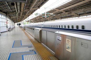 Atami, Japonya- 30 Ekim 2024: JR (Japonya Demiryolu) Merkez N700 Shinkansen mermi treni gündüz vakti istasyona yüksek hızda giriş yapıyor.