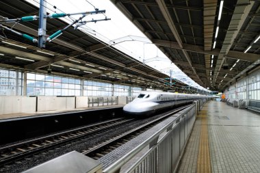 Atami, Japan- 30 Oct 2024: JR ( Japan Railway) Central N700 Shinkansen bullet train entering the station platform in daytime with high speend clipart