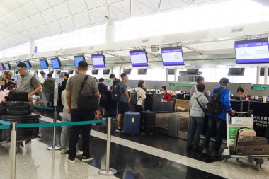 Hong Kong Uluslararası Havalimanı, Chek Lap Kok, Hong Kong - 2 Kasım 2024: Hong Kong Ekspresi 'nin karşısındaki çekte yer almak ve bavulları bırakmak için kuyrukta bekleyen yolcular