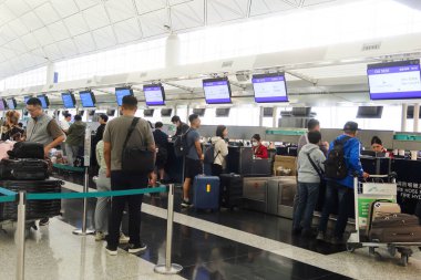 Hong Kong Uluslararası Havalimanı, Chek Lap Kok, Hong Kong - 2 Kasım 2024: Hong Kong Ekspresi 'nin karşısındaki çekte yer almak ve bavulları bırakmak için kuyrukta bekleyen yolcular