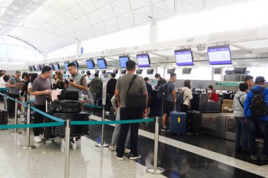 Hong Kong Uluslararası Havalimanı, Chek Lap Kok, Hong Kong - 2 Kasım 2024: Hong Kong Ekspresi 'nin karşısındaki çekte yer almak ve bavulları bırakmak için kuyrukta bekleyen yolcular