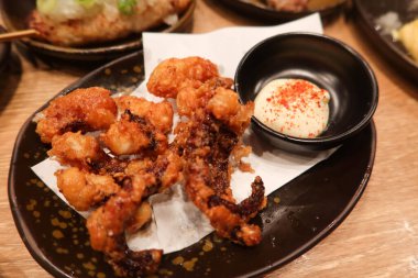 Japon Izakaya restoranının yanında salata soslu ahtapot bacakları yakın çekim.