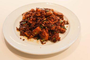 close up of Singaporean stir fried xo seafood sauce with egg, fried shrimp and carrot cake on a white plate clipart